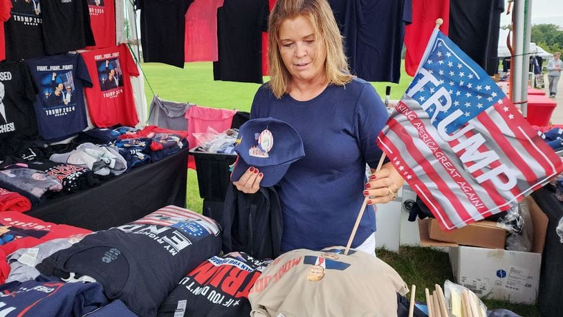 Jody Cordonnier, from Piqua, buys Trump gear at a vendor before a rally for Vice Presidential candidate J.D. Vance Monday, July 22, 2024 at Middletown High School. NICK GRAHAM/STAFF