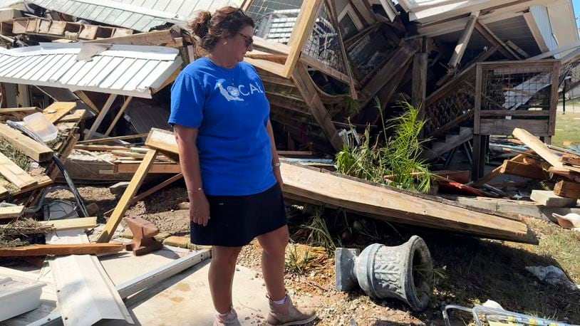 Laurie Lilliott stands amid the wreckage of her destroyed home in Dekle Beach in rural Taylor County, Fla., Friday, Sept. 27, 2024, in the aftermath of Hurricane Helene. (AP Photo/Kate Payne)