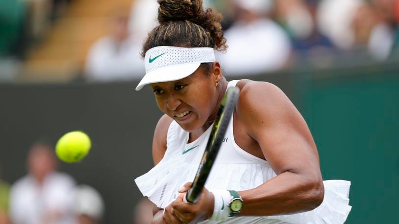 Naomi Osaka of Japan plays a backhand return to Diane Parry of France during their first round match of the Wimbledon tennis championships in London, Monday, July 1, 2024. (AP Photo/Kirsty Wigglesworth)