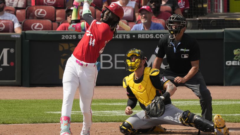 Cincinnati Reds' Elly De La Cruz watches his three-run homer with Pittsburgh Pirates catcher Yasmani Grandal (6) and home plate umpire Charlie Ramos during the fourth inning of a baseball game, Saturday, Sept. 21, 2024, in Cincinnati. (AP Photo/Carolyn Kaster)