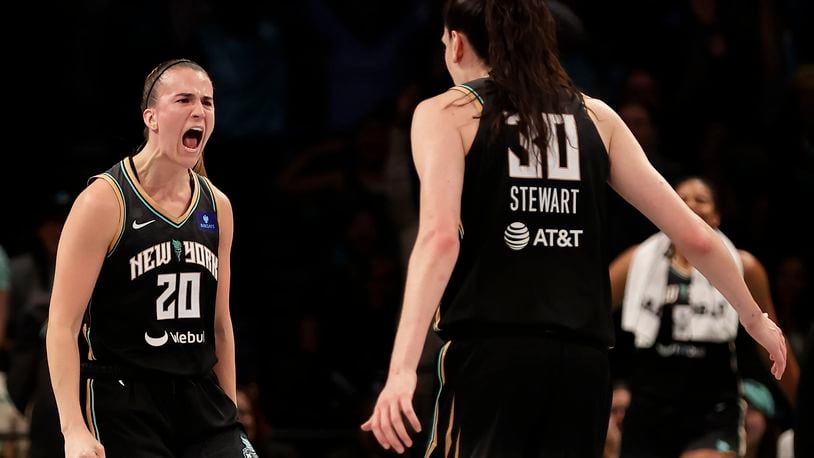 New York Liberty guard Sabrina Ionescu (20) reacts with Breanna Stewart (30) during the first half of a first-round WNBA basketball playoff game against the Atlanta Dream, Tuesday, Sept. 24, 2024, in New York. (AP Photo/Adam Hunger)