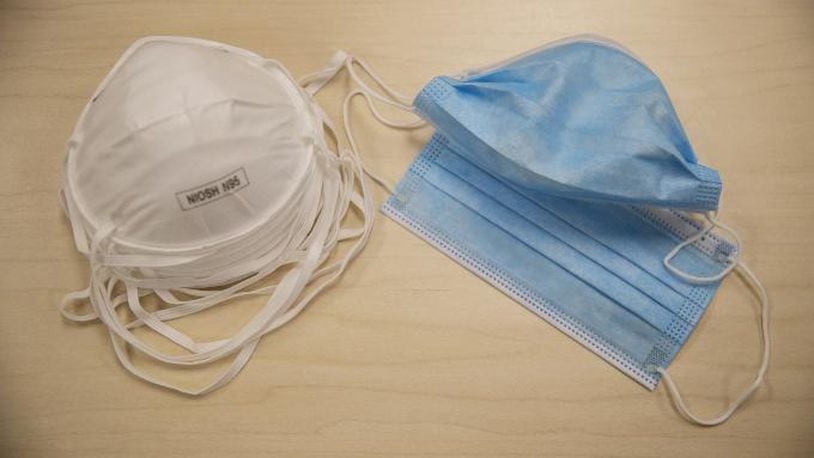 FILE: N95 particulate respirator masks and procedure face masks are arranged for a photograph.