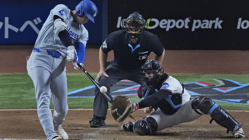 Los Angeles Dodgers' Shohei Ohtani, of Japan, hits a home run scoring Hunter Feduccia during the third inning of a baseball game against the Miami Marlins, Tuesday, Sept. 17, 2024, in Miami. (AP Photo/Wilfredo Lee)