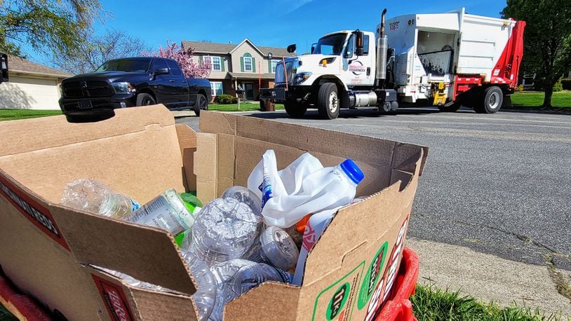 Rumpke employee Michael McDonald collects recyclable materials during his route Friday, April 16, 2021 in West Chester Twp. NICK GRAHAM / STAFF