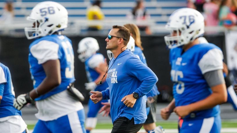 Hamilton head football coach Nate Mahon runs up the field with the team during warm-ups before their game against Anderson Friday, Sept. 6, 2019, at Virgil M. Schwarm Stadium in Hamilton. Big Blue won 28-14. NICK GRAHAM/STAFF