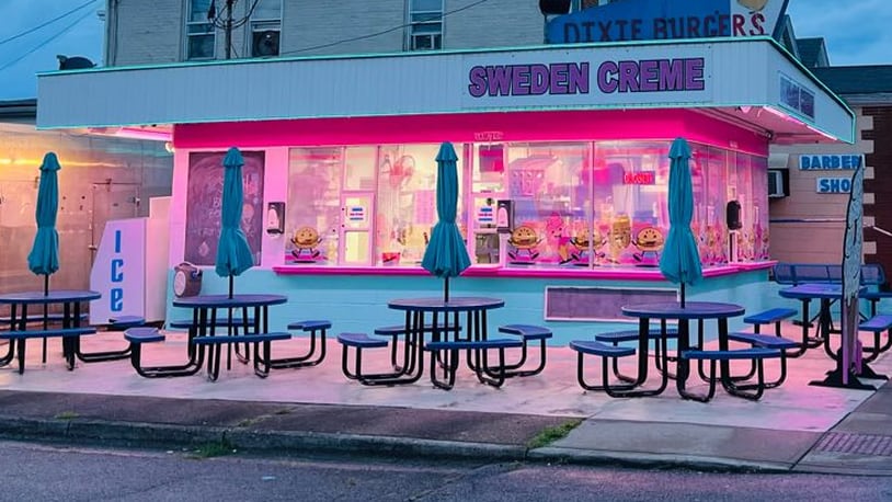 Sweden Creme in Lindenwald, a neighborhood of Hamilton, is painted pink and light blue, and the building is lit up with neon lights at night. Metal tables with built-in benches and umbrellas and picnic-table style seating are available outdoors. A new sign advertises the signature Dixie Burger. The windows are decorated with dancing Dixie Burgers and ice cream cones. CONTRIBUTED