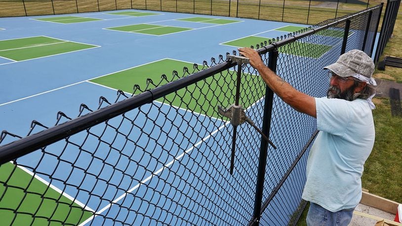 Mark Gilbert, with Ashlee Fence, installs fence around nine new picklball courts at Lefferson Park Monday, June 17, 2024 in Middletown. NICK GRAHAM/STAFF