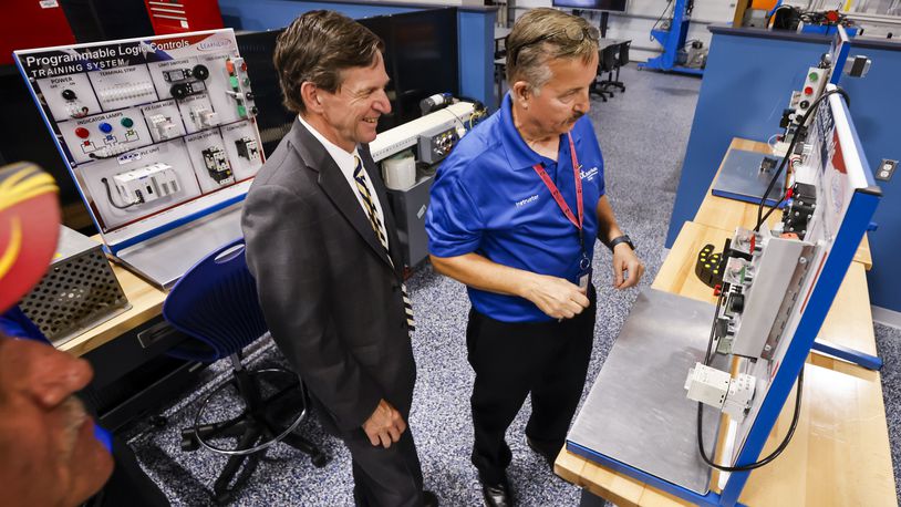 John Magill, with Ohio Department of Higher Education, speaks, left, gets a tour by instructor Harry Beal after a ribbon cutting for the adult education Robotics lab and Industrial Maintenance Technology lab at their LeSourdsville campus Wednesday, Aug. 21, 2024. NICK GRAHAM/STAFF