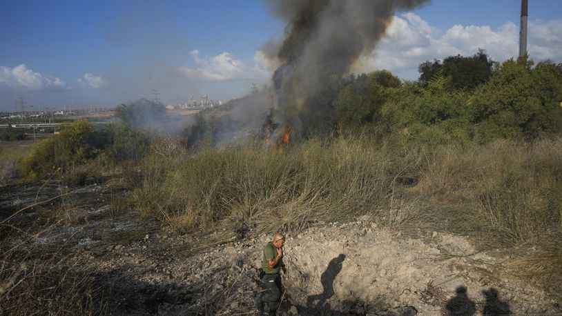 A police officer inspects the area around a fire after the military said it fired interceptors at a missile launched from Yemen that landed in central Israel on Sunday, Sept. 15, 2024. (AP Photo/Ohad Zwigenberg)