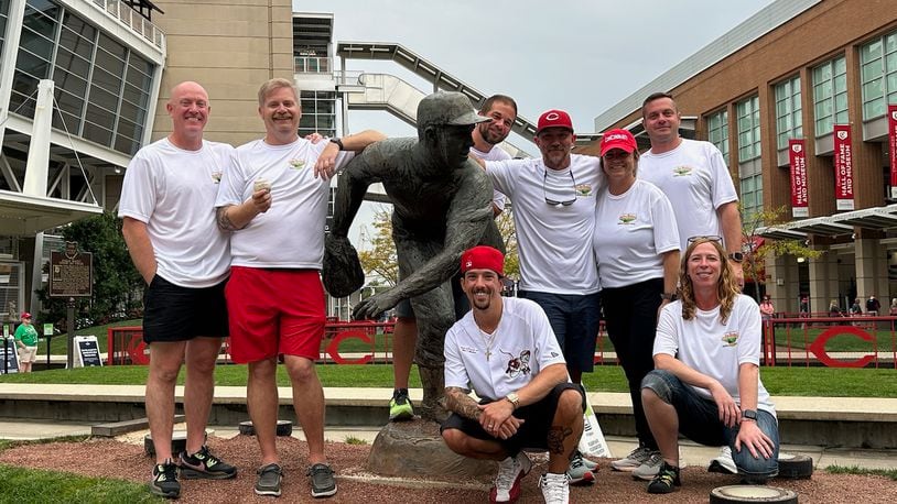 These eight people walked the 21 miles from Fairfield to Great American Ball Park Tuesday night. They raised money for the Joe Nuxhall Miracle League Fields. Pictured by the Nuxhall statue are, front row: Sean Fogelson and Cathy Heil; back row: Ryan O'Brien, Jared Baker, Eric Judd, Ben Otto, Laura Otto and Tyler Parker. SUBMITTED PHOTO