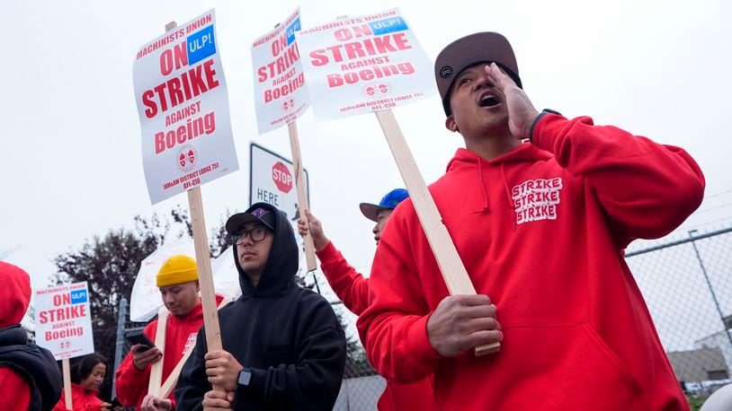 Boeing wing mechanic lead Lee Lara, who has worked for the company for 16 years, yells in response to honks from passing drivers as workers wave picket signs while striking after union members voted to reject a contract offer, Sunday, Sept. 15, 2024, near the company's factory in Everett, Wash. (AP Photo/Lindsey Wasson)