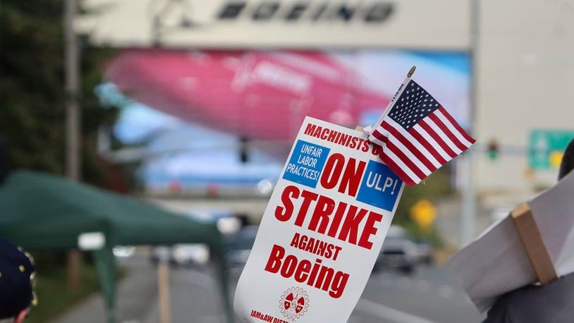 A strike sign is waved on the union machinist picket line near Boeing's factory in Everett, Washington, Thursday, Sept. 19, 2024. (AP Photo/Manuel Valdes)