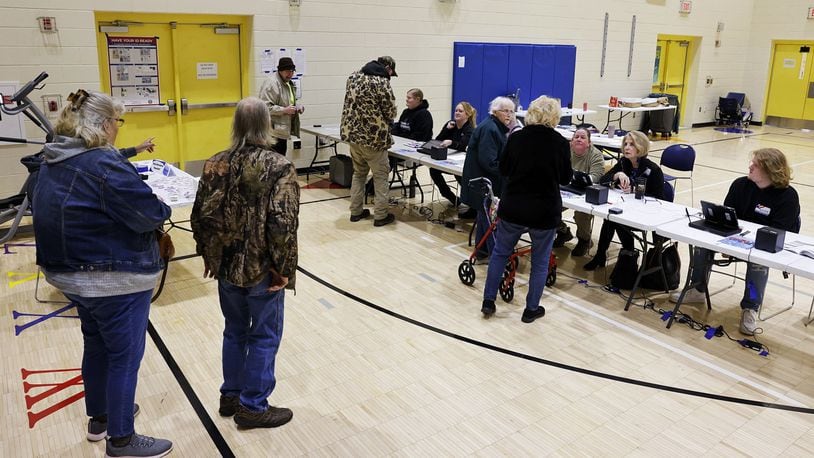 Poll workers check in voters on election day Tuesday, March 19, 2024 at Highland Elementary School in Hamilton. NICK GRAHAM/STAFF