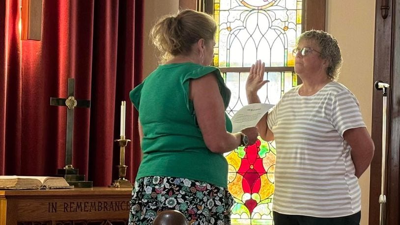 Seven Mile Mayor Melissa Mick, left, swears in Kathy Allen as the village's first female assistant fire chief during a ceremony at Seven Mile Presbyterian Church where Allen is a member. PROVIDED PHOTO