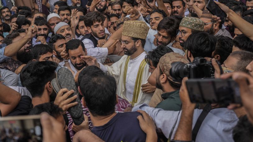 FILE- Supporters assemble to welcome top Kashmiri separatist leader Mirwaiz Umar Farooq, center, as he arrives to offer Friday prayers outside the Jamia Masjid or Grand Mosque in Srinagar, Indian controlled Kashmir, Sept. 22, 2023. (AP Photo/Mukhtar Khan, File)