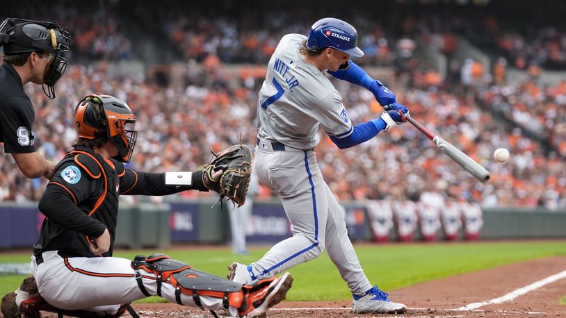 Kansas City Royals' Bobby Witt Jr. (7) hits a single as home plate umpire Ben May, left, and Baltimore Orioles catcher Adley Rutschman look on during the third inning in Game 2 of an AL Wild Card Series baseball game, Wednesday, Oct. 2, 2024 in Baltimore. (AP Photo/Stephanie Scarbrough)