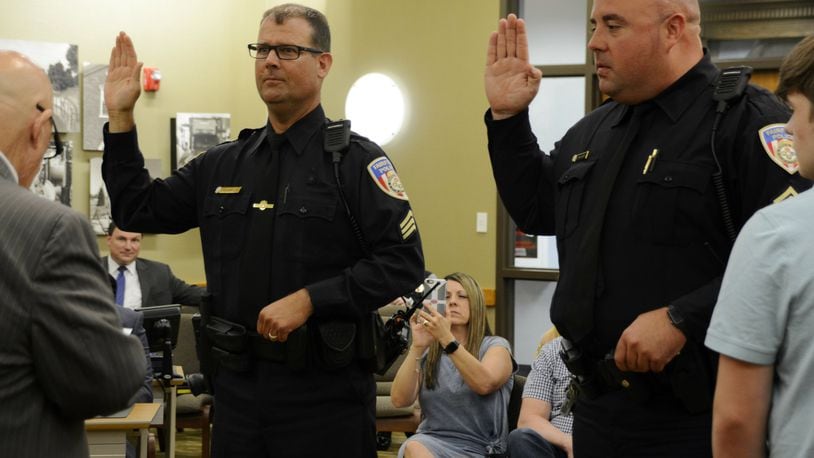 Fairfield police Sgts. Kevin Harrington, left, and Mike Woodall take their oaths of office during a ceremonial promotion ceremony before City Council on July 8. MICHAEL D. PITMAN/STAFF