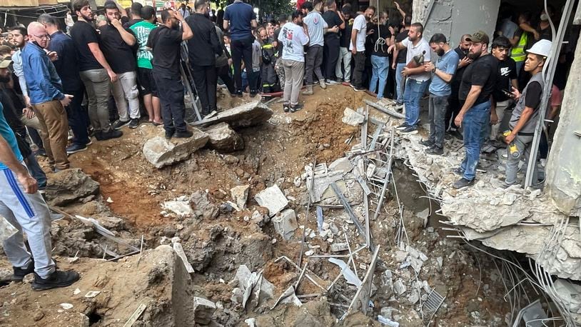 People gather at the scene of an Israeli missile strike in the southern suburbs of Beirut, Friday, Sept. 20, 2024. (AP Photo/Bilal Hussein)