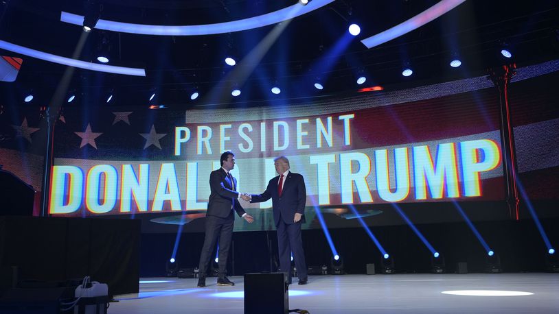 FILE - Former President Donald Trump, right, shakes hands with Turning Point CEO Charlie Kirk before speaking during the Turning Point USA Student Action Summit, Saturday, July 23, 2022, in Tampa, Fla. (AP Photo/Phelan M. Ebenhack, File)