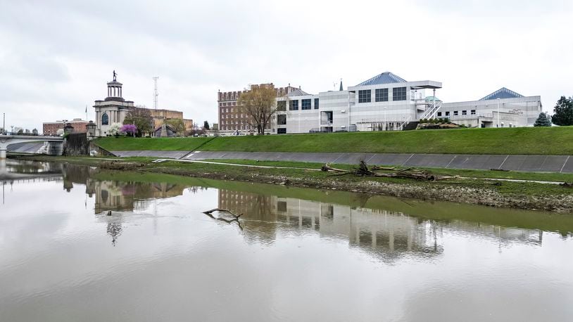 A view of the Fitton Center for Creative Arts and the Butler County Soldiers, Sailors and Pioneers Monument reflected in the Great Miami River Wednesday, April 10, 2024 in Hamilton. NICK GRAHAM/STAFF