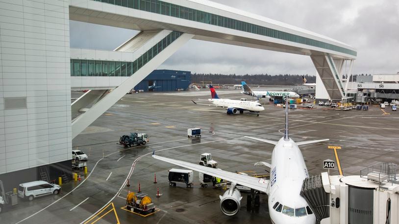 FILE - Planes taxi under the aerial passenger walkway at Seattle-Tacoma International Airport, March 3, 2022, in Seattle. (Ken Lambert/The Seattle Times via AP, File)