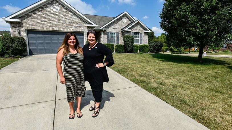 Katie Rowland, left, stands by Donna Deaton with RE/MAX Victory realtors in front of the house Rowland is selling in Monroe. Rowland, who is having a home built in Liberty Twp., sold her home on the first day it was listed. NICK GRAHAM/STAFF