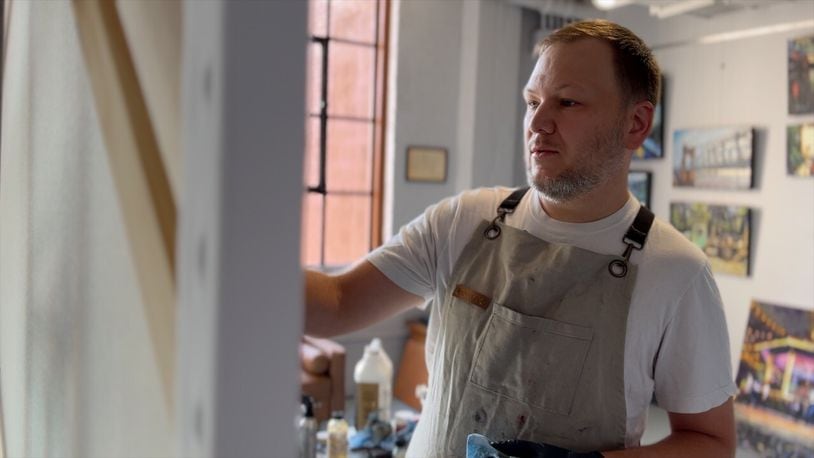 Artist Tony Lipps paints a picture of Cincinnati Bengals quarterback Joe Burrow. Lipps used to work as a corrections officer in the jail in Queensgate. Now, he paints full-time in a studio reimagined in the old jail building. KEITH BIERYGOLICK/WCPO