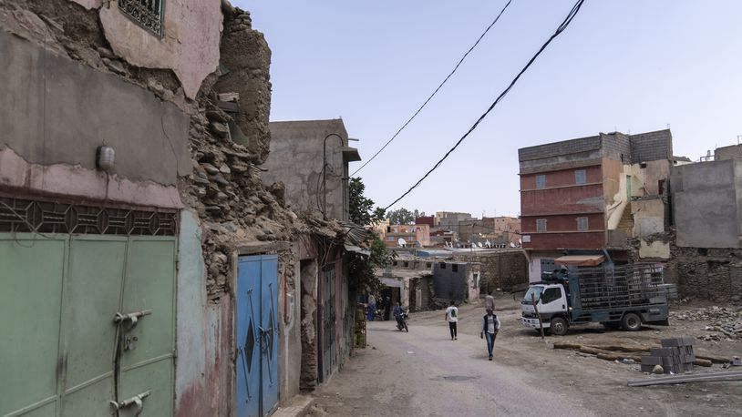 People walk past buildings which were affected by the 2023 earthquake, in the town of Amizmiz, outside Marrakech, Morocco, Wednesday, Sept. 4, 2024. (AP Photo/Mosa'ab Elshamy)