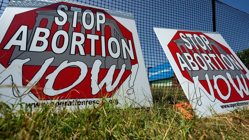 Anti-abortion signs lean agains a fence outside a recently opened Planned Parenthood clinic in Pittsburg, Kan., Tuesday, Sept. 10, 2024. (AP Photo/Charlie Riedel)