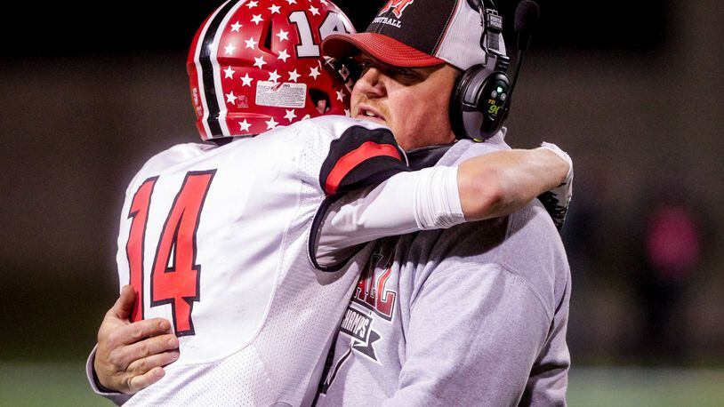 Madison coach Steve Poff hugs Noah Lehman after their 24-16 loss to Wheelersburg in the Division V, Region 20 final on Nov. 17, 2018, at Hilliard Darby High School in Hilliard. NICK GRAHAM/STAFF