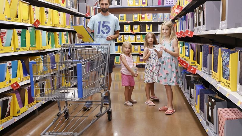 Zack Hinger shops for school supplies with daughters Lily, 8, Theresa, 6, and Cece, 4, at Walmart Tuesday, July 23, 2024 in West Chester Township. Ohio's sales tax holiday is July 30 to Aug. 8 running 10 days instead of 3 days from last year and includes more than just school supplies and clothing. NICK GRAHAM/STAFF