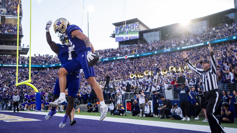 Washington wide receiver Denzel Boston, front, celebrates his touchdown with running back Jonah Coleman (1) during the first half of an NCAA college football game against Michigan, Saturday, Oct. 5, 2024, in Seattle. (AP Photo/Lindsey Wasson)