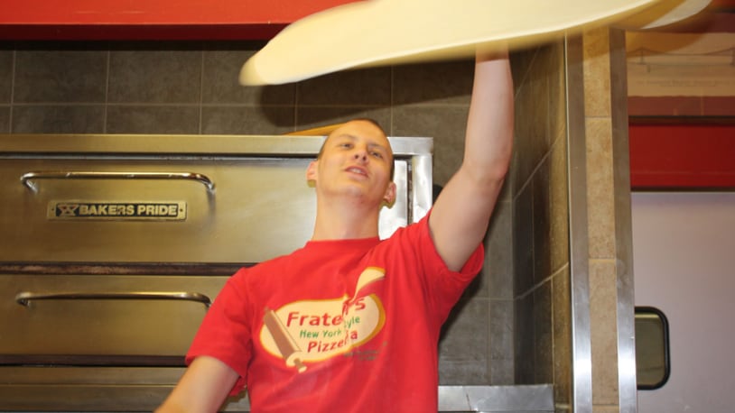 Joey Frederickson prepares a New York-style pizza at Fratelli's Pizzeria in West Chester Twp. CONTRIBUTED