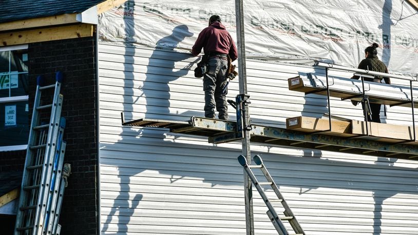 Crews install siding on a house being built by Cristo Homes on Governors Avenue Thursday, Feb. 21 in Trenton. NICK GRAHAM/STAFF
