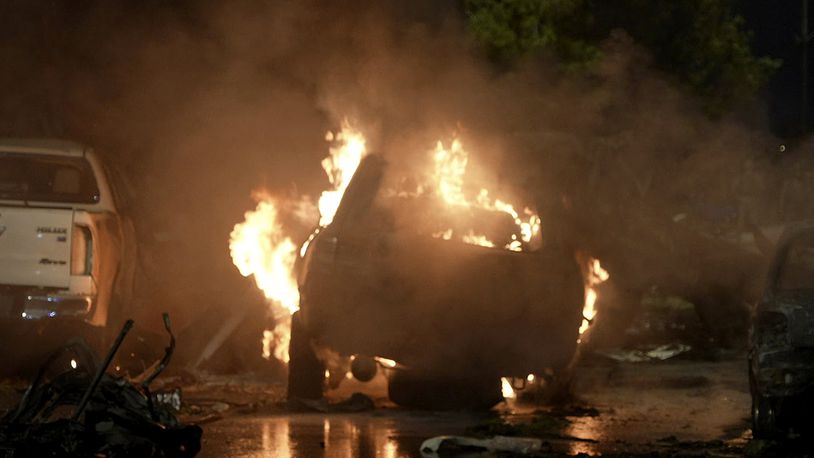 A vehicle is seen on fire at the site of an explosion that caused injures and destroyed vehicles at outside the Karachi airport, Pakistan, Sunday, Oct. 6, 2024. (AP Photo/Mohammad Farooq)