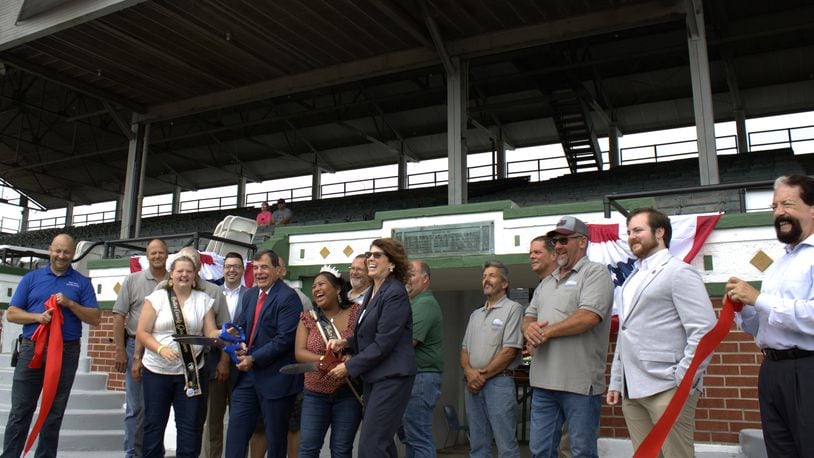 Local officials, leaders and representatives gathered around the grandstands at the Butler County Fairgrounds on July 22, 2024 for a ribbon-cutting ceremony that unveiled the updates from the $750,000 restoration that took place in the past year. The restoration focused on the structural integrity of the grandstands and cosmetic maintenance. KASEY TURMAN/STAFF