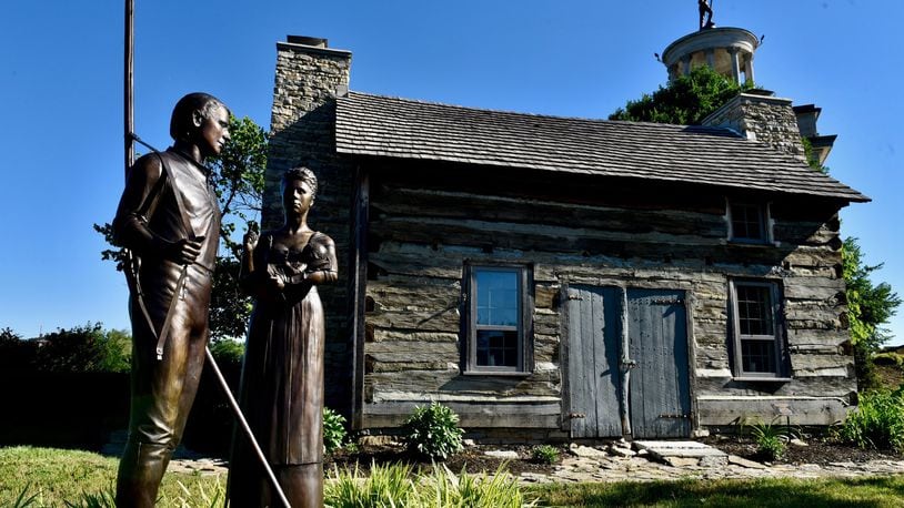 A historic log cabin dating to 1802 sits next to the Sailors, Soldiers and Pioneers monument in Hamilton. NICK GRAHAM / STAFF
