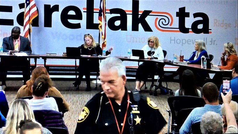 A Butler County Sheriff deputy moves among the sometimes raucous crowd at Monday evening's Lakota school board meeting, which saw members vote to temporarily halt comments from the public. The meeting was abruptly adjourned after regular board business had been conducted but prior to the meeting's closing comments by members. (Photo By Michael D. Clark\Journal-News)