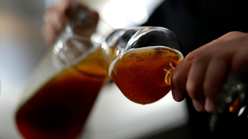 An employee of the Technical University of Munich fills beer in the brewery in Freising, Germany, Thursday, Sept. 19, 2024. (AP Photo/Matthias Schrader)