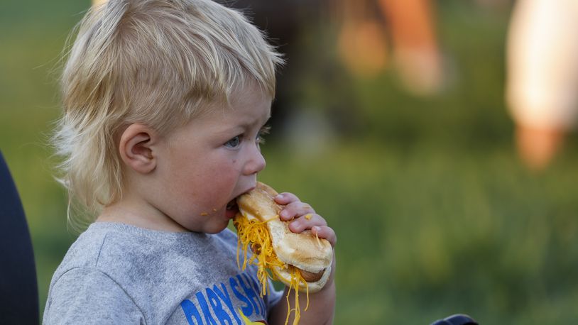 Jackson Messer, 1, eats a Gold Star Chili cheese coney during the Middletown Division of Police National Night Out event Tuesday, Aug. 2, 2022 at Smith Park. There were police k-9 and swat demonstrations, CareFlight helicopter, dunking booth, free food from Gold Star Chili and Kona Ice, bouncy houses, vendors and more. NICK GRAHAM/STAFF