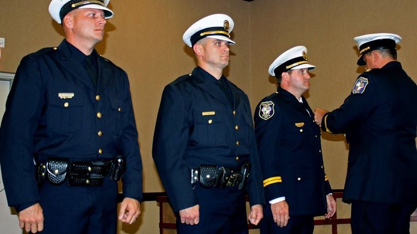 West Chester Police Chief Joel Herzog, far right, performs the honors at an Oct. 11 pinning ceremony to mark the promotions of three West Chester Police officers from left, Paul Brent Lovell, promoted to Sergeant; Christopher Whitton, promoted to Lieutenant; and Joseph Gutman, promoted to Captain. CONTRIBUTED