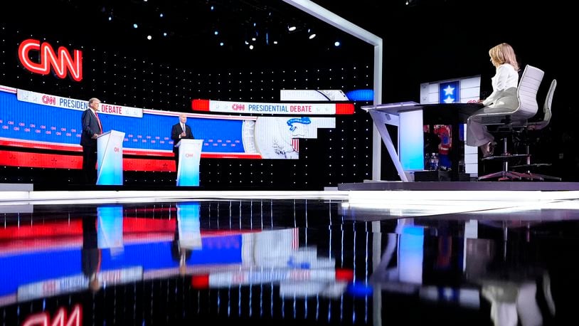 President Joe Biden, on stage at right, and Republican presidential candidate former President Donald Trump, left, participate in a presidential debate hosted by CNN, Thursday, June 27, 2024, in Atlanta. At far right is CNN moderator Dana Bash. (AP Photo/Gerald Herbert)