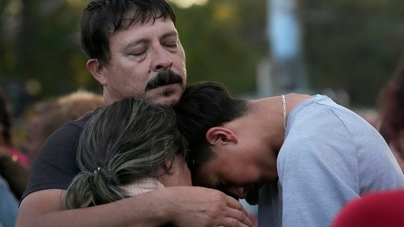 Daniel Delgado, top, is comforted by his 16-year-old son Angel Delgado, right, as he mourns the loss of his wife and Angel's mother, Monica Hernandez, who died at Impact Plastics during flooding caused by Hurricane Helene in Erwin, Tenn., on Thursday, Oct. 3, 2024. (AP Photo/Jeff Roberson)