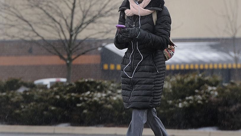 A woman bundles up against the cold as she walks along Old Troy Pike in Huber Heights, Monday, Jan. 25, 2021. MARSHALL GORBY\STAFF