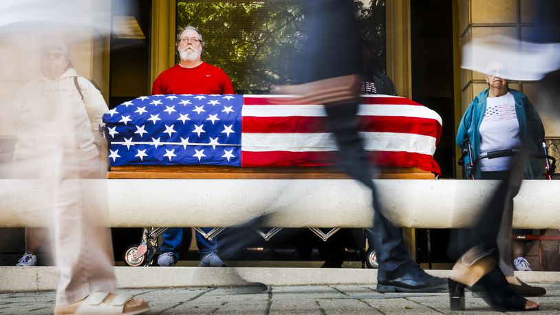 Left to right: June Owens, Navy veteran Steve Murray, Army veteran Dan VanDyne and Dixie Owens stand over a flag-draped casket as Butler County Veterans Service Commission and volunteers participate in a Silent Watch for veteran suicide awareness Wednesday, Sept. 20, 2023 outside the Veterans Service Commission office on High Street in Hamilton. NICK GRAHAM/STAFF