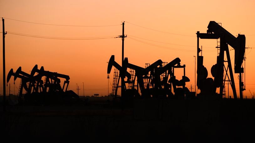 FILE - An array of pumpjacks operate near the site of a new oil and gas well being drilled April 8, 2022 in Midland, Texas. (Eli Hartman/Odessa American via AP, File)