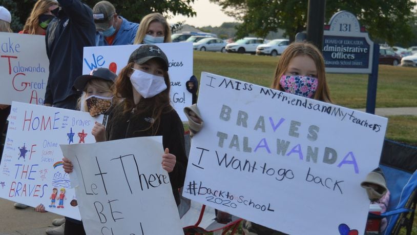 Young Talawanda students were out early in a chilly morning in support of their parents seeking a return to face-to-face classroom learning. CONTRIBUTED/BOB RATTERMAN
