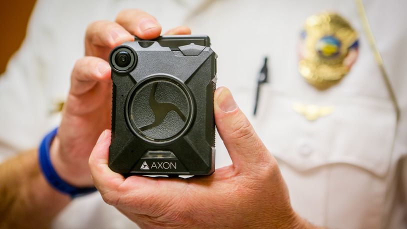 Sgt. Brian Robinson of the Hamilton Police Department displays an Axon body camera, one the cameras the department is currently testing. The Hamilton Police Department plans to have all frontline officers in body cameras by the end of 2017. GREG LYNCH / STAFF