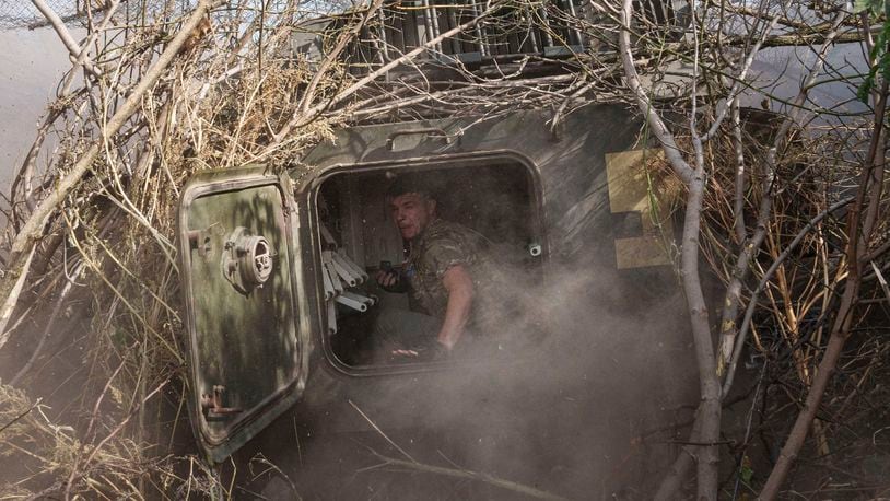 Ukrainian serviceman of 56th brigade sits inside self-propelled artillery vehicle while firing towards Russian positions at the frontline on Chasiv Yar direction, Donetsk region, Ukraine, Sept. 27, 2024. (AP Photo/Evgeniy Maloletka)