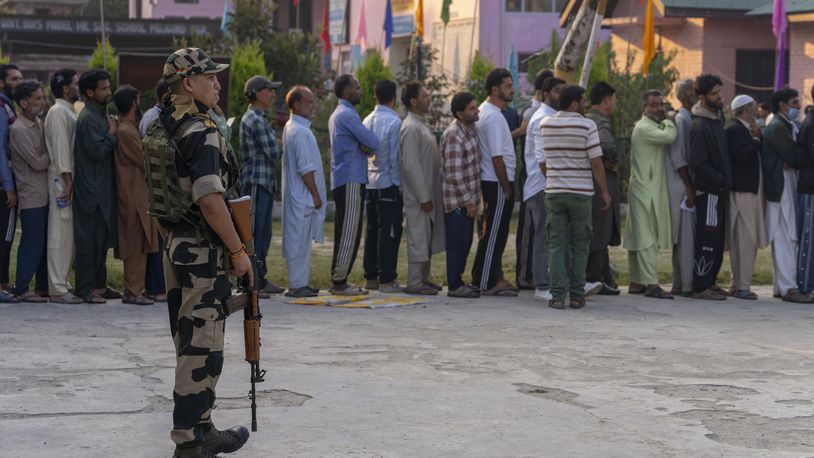 An Indian paramilitary soldier stands guard as Kashmiri's queue up at a polling booth to cast their vote during the second phase of the assembly election in the outskirts of Srinagar, Indian controlled Kashmir, Wednesday, Sept. 25, 2024. (AP Photo/Dar Yasin)